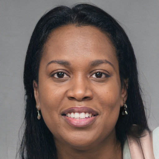 Joyful black young-adult female with long  brown hair and brown eyes