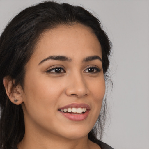 Joyful latino young-adult female with long  brown hair and brown eyes