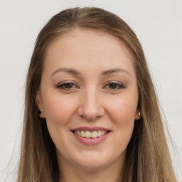 Joyful white young-adult female with long  brown hair and brown eyes