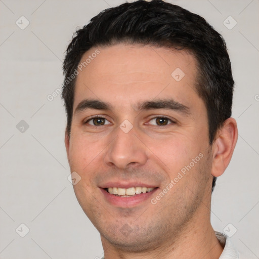 Joyful white young-adult male with short  black hair and brown eyes