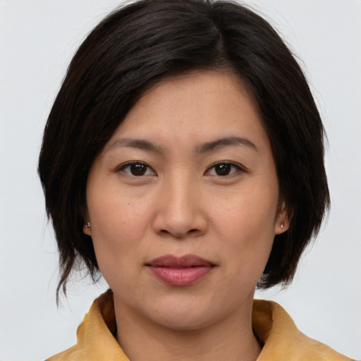 Joyful asian young-adult female with medium  brown hair and brown eyes