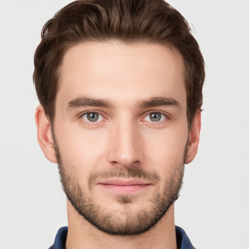 Joyful white young-adult male with short  brown hair and grey eyes