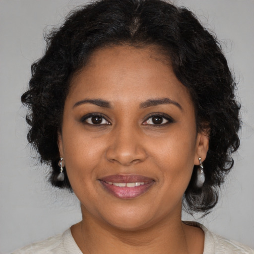Joyful black young-adult female with medium  brown hair and brown eyes