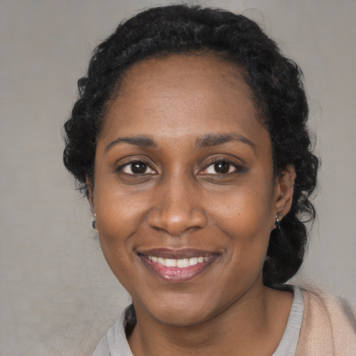 Joyful black adult female with short  black hair and brown eyes