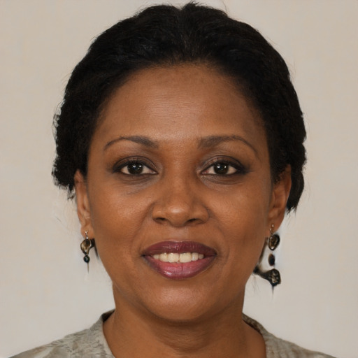 Joyful black adult female with medium  brown hair and brown eyes