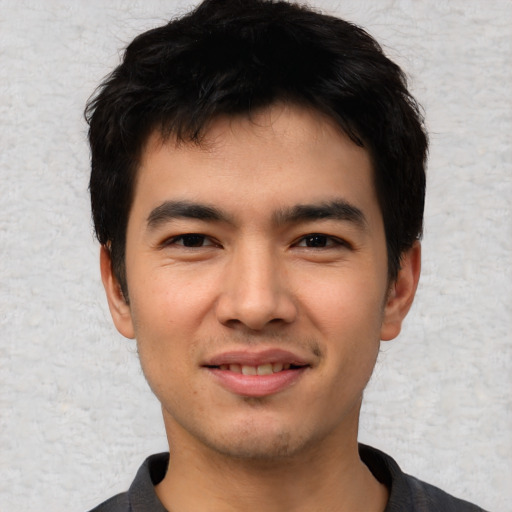 Joyful asian young-adult male with short  black hair and brown eyes