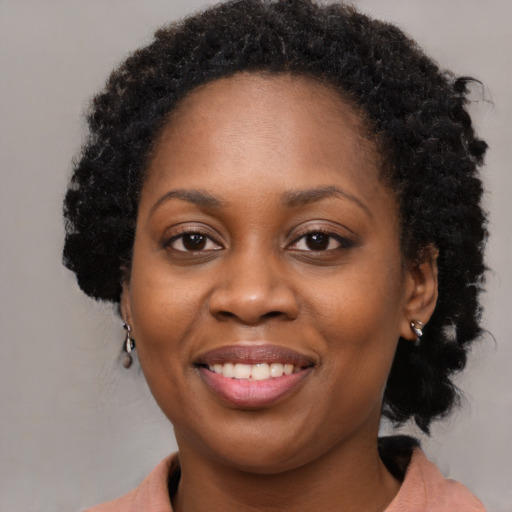 Joyful black young-adult female with medium  brown hair and brown eyes