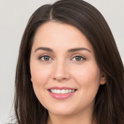 Joyful white young-adult female with long  brown hair and brown eyes