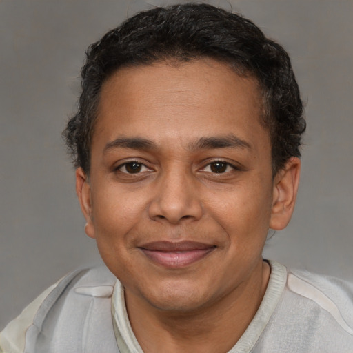 Joyful black adult male with short  brown hair and brown eyes