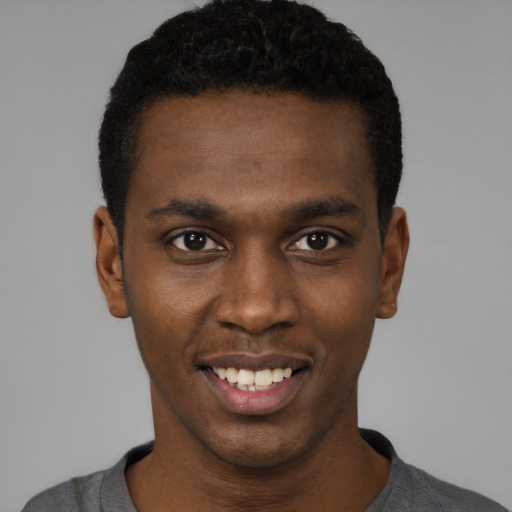 Joyful black young-adult male with short  black hair and brown eyes