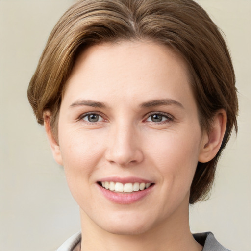 Joyful white young-adult female with medium  brown hair and grey eyes