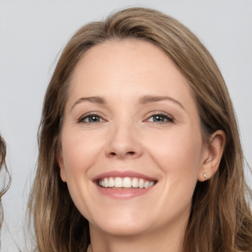 Joyful white young-adult female with long  brown hair and grey eyes