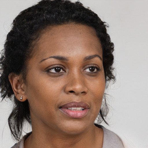 Joyful black young-adult female with medium  brown hair and brown eyes