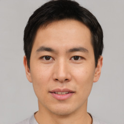 Joyful asian young-adult male with short  brown hair and brown eyes