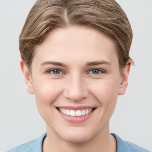 Joyful white young-adult female with short  brown hair and grey eyes