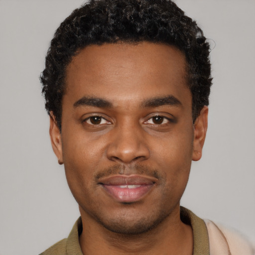 Joyful black young-adult male with short  black hair and brown eyes