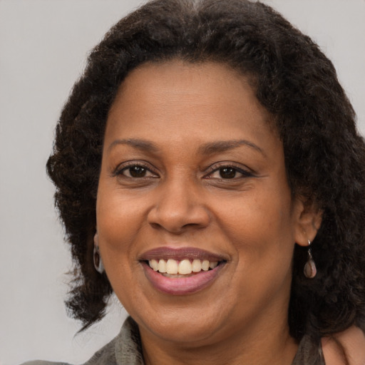 Joyful black adult female with long  brown hair and brown eyes