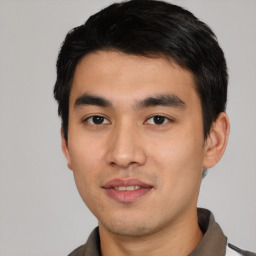 Joyful asian young-adult male with short  black hair and brown eyes