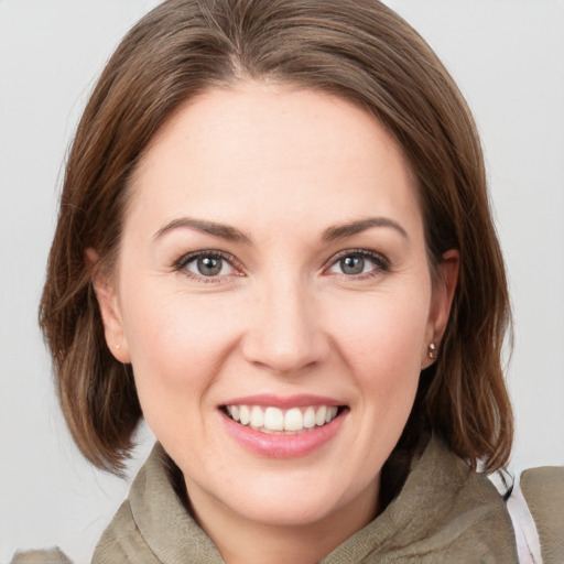 Joyful white young-adult female with medium  brown hair and grey eyes