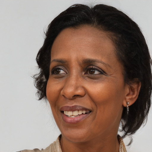 Joyful black adult female with medium  brown hair and brown eyes