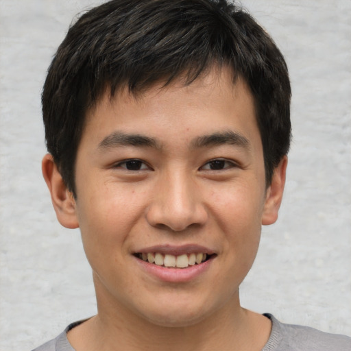 Joyful asian young-adult male with short  brown hair and brown eyes