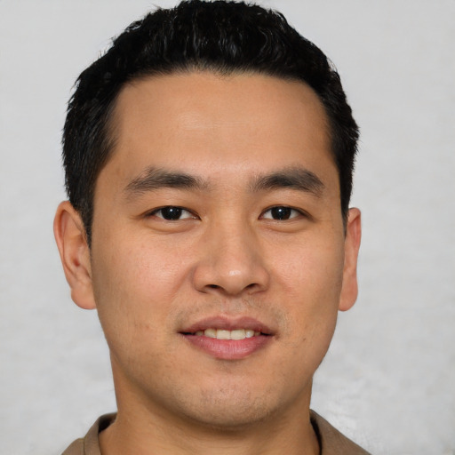 Joyful asian young-adult male with short  brown hair and brown eyes