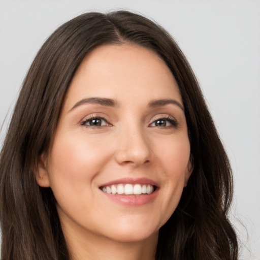 Joyful white young-adult female with long  brown hair and brown eyes