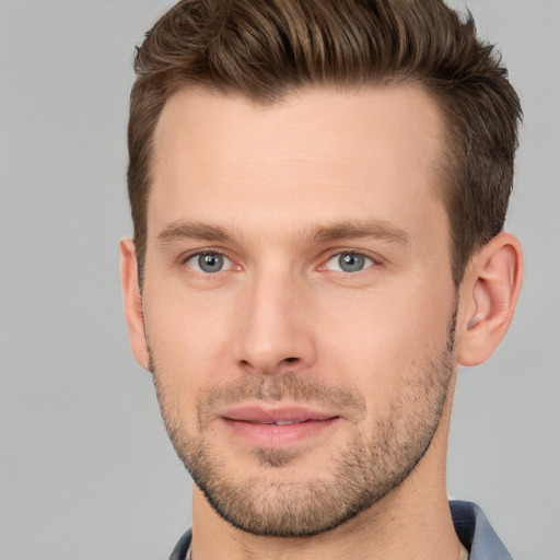 Joyful white young-adult male with short  brown hair and grey eyes