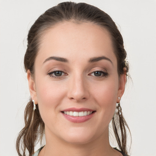 Joyful white young-adult female with medium  brown hair and grey eyes