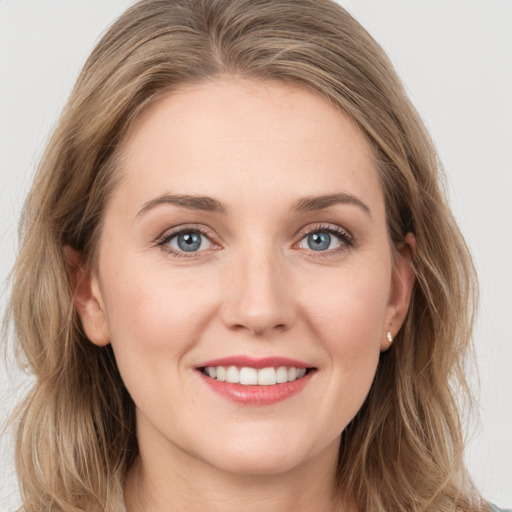 Joyful white young-adult female with long  brown hair and blue eyes