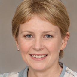 Joyful white adult female with medium  brown hair and grey eyes