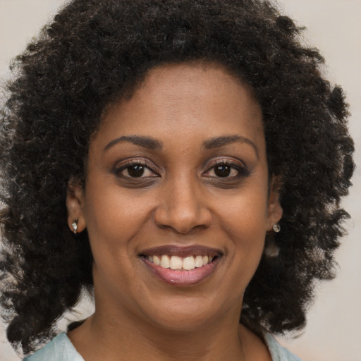 Joyful black young-adult female with medium  brown hair and brown eyes