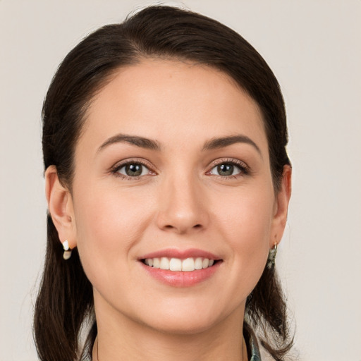 Joyful white young-adult female with medium  brown hair and grey eyes