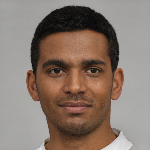 Joyful black young-adult male with short  brown hair and brown eyes