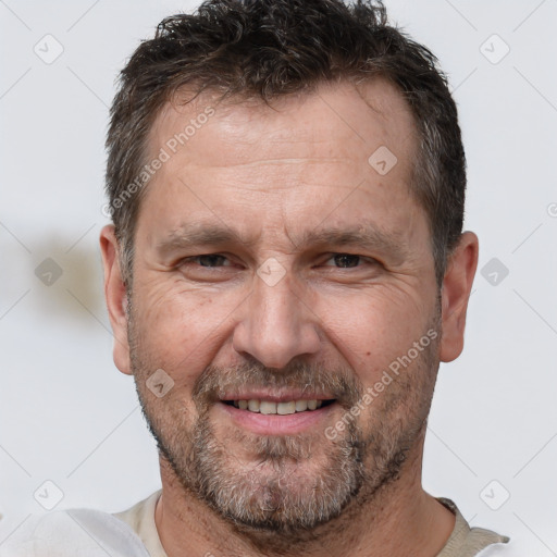 Joyful white adult male with short  brown hair and brown eyes