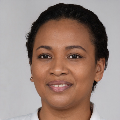 Joyful black young-adult female with short  black hair and brown eyes