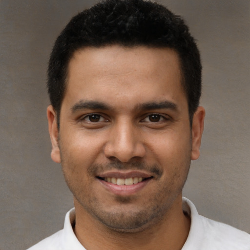 Joyful white young-adult male with short  black hair and brown eyes