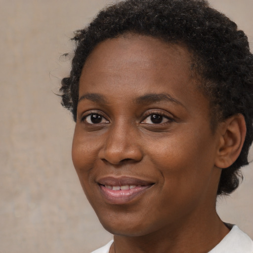 Joyful black young-adult female with short  brown hair and brown eyes