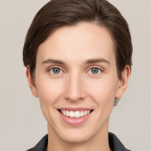 Joyful white young-adult female with short  brown hair and grey eyes