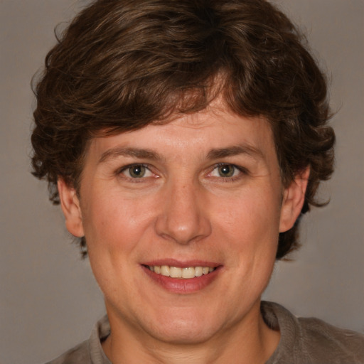 Joyful white adult female with medium  brown hair and grey eyes