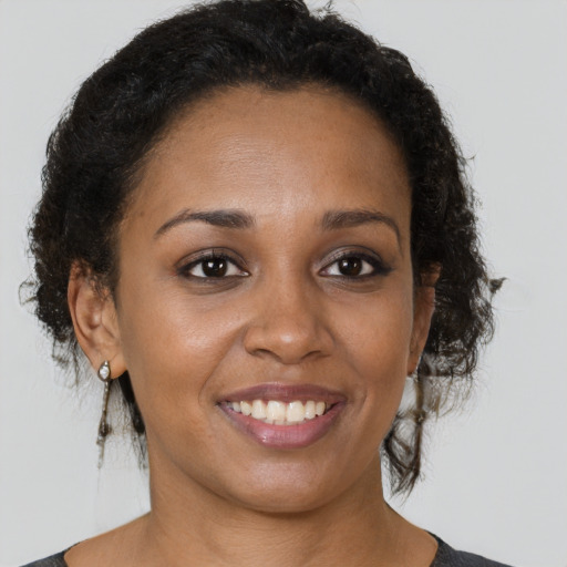 Joyful black young-adult female with short  brown hair and brown eyes