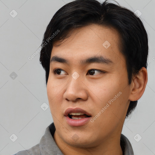 Joyful asian young-adult male with short  black hair and brown eyes