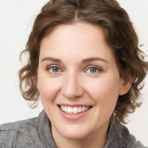 Joyful white young-adult female with medium  brown hair and blue eyes