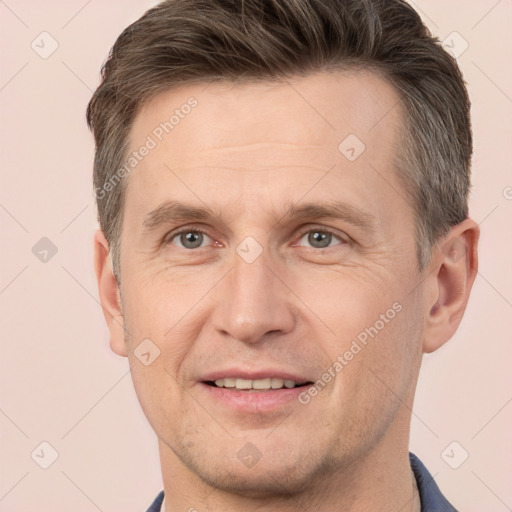 Joyful white adult male with short  brown hair and brown eyes