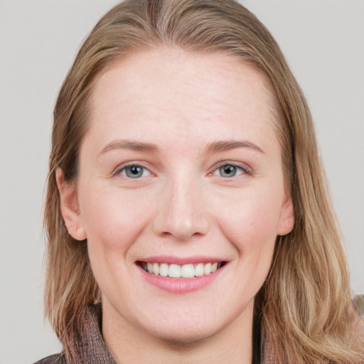 Joyful white young-adult female with long  brown hair and blue eyes