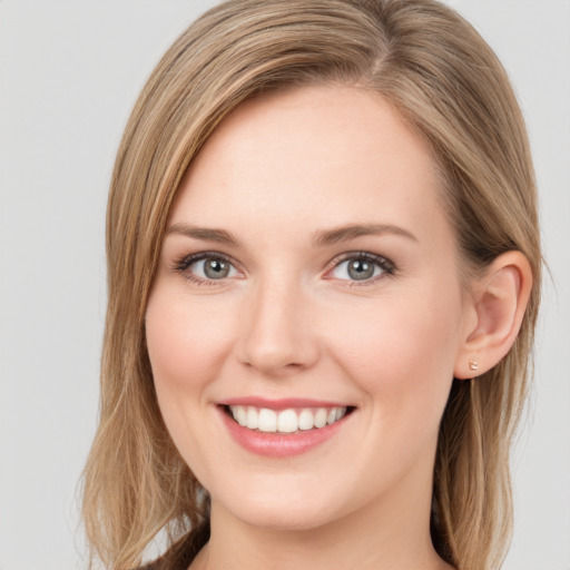 Joyful white young-adult female with long  brown hair and green eyes