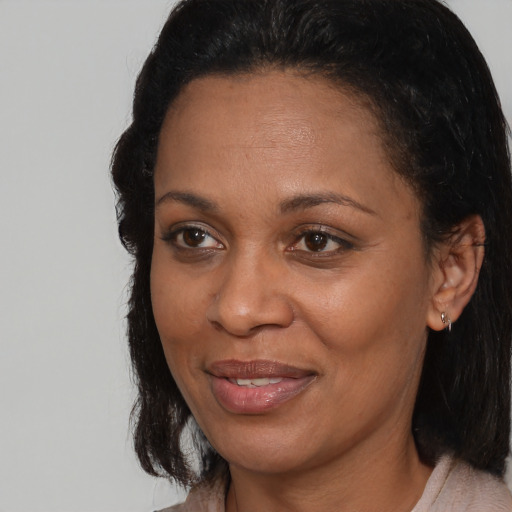 Joyful black adult female with medium  brown hair and brown eyes