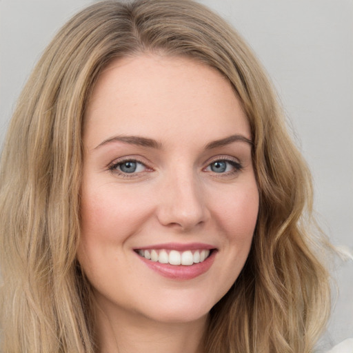 Joyful white young-adult female with long  brown hair and green eyes