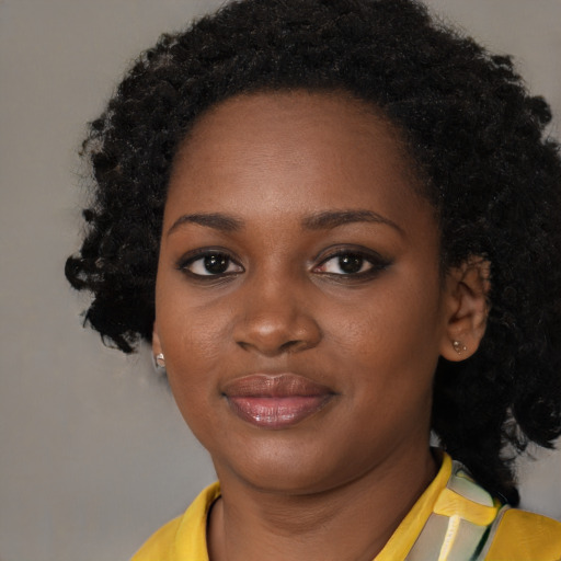 Joyful black young-adult female with short  black hair and brown eyes