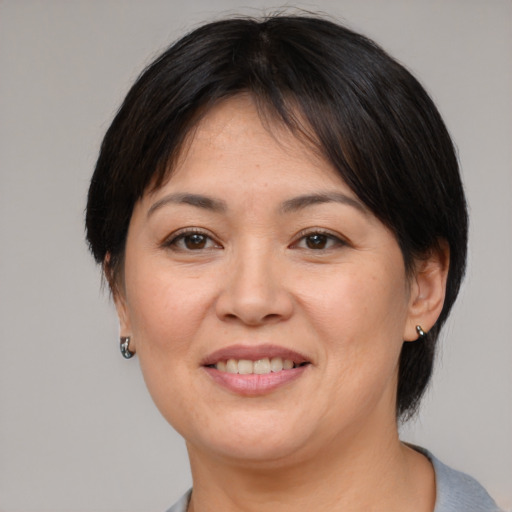 Joyful asian adult female with medium  brown hair and brown eyes